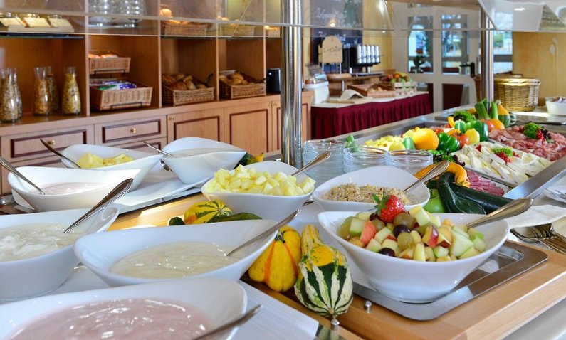 Leckeres Frühstücksbuffet im Hotel Frühstücksraum mit Cerealien, Wurst, Käse, Gemüse, Brötchen, Joghurt